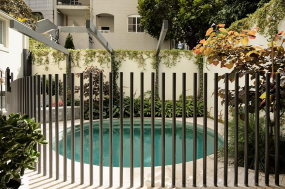 Gallery Image Small round backyard pool with vertical safety fencing and landscaped garden