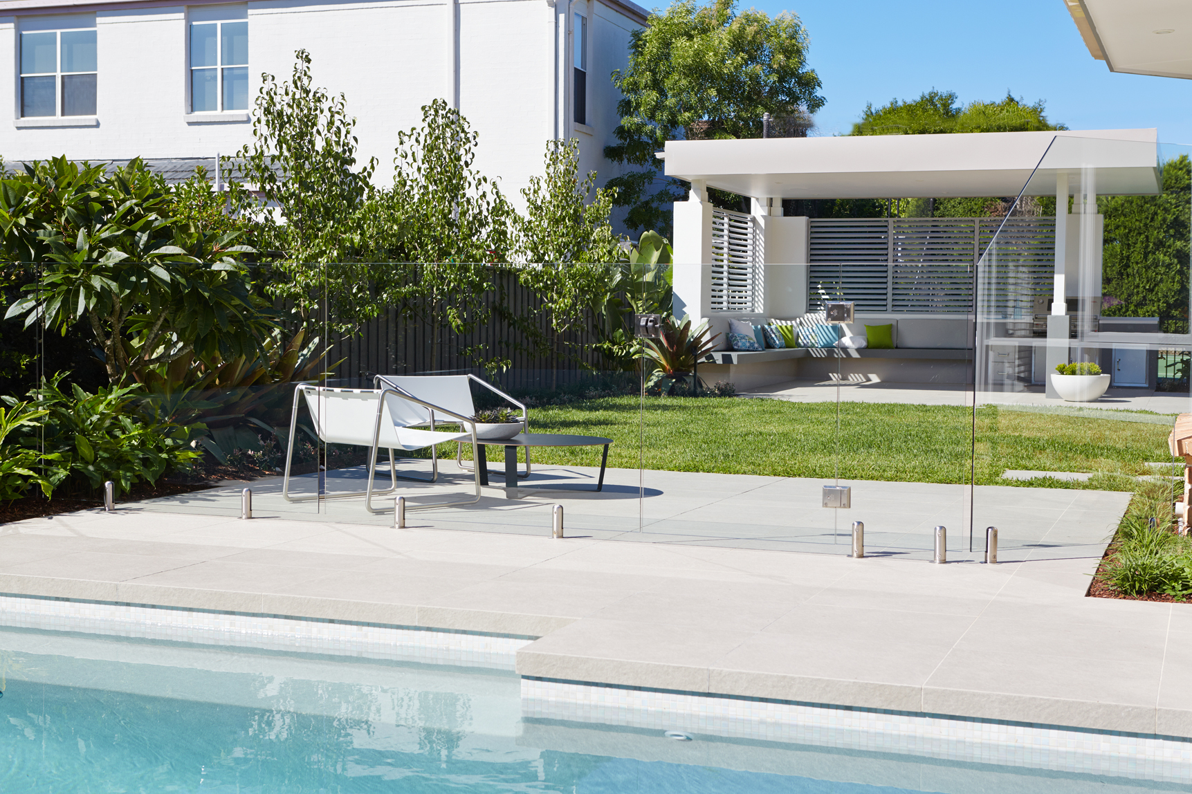 Gallery Image Modern backyard pool with glass fencing, outdoor seating and landscaped garden in Castle Hill